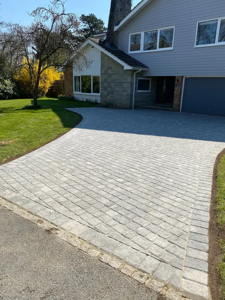 Wide view of grey block-paved driveway with contrasting edging.