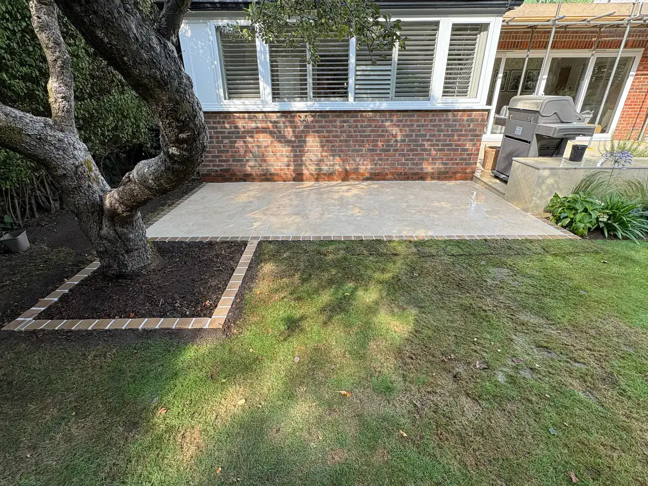 Completed paved patio with contrasting edging around a tree bed.