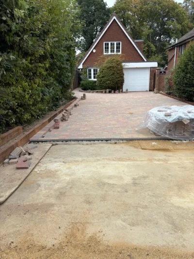 Block-paved driveway during installation, with prepared ground and paving in place.