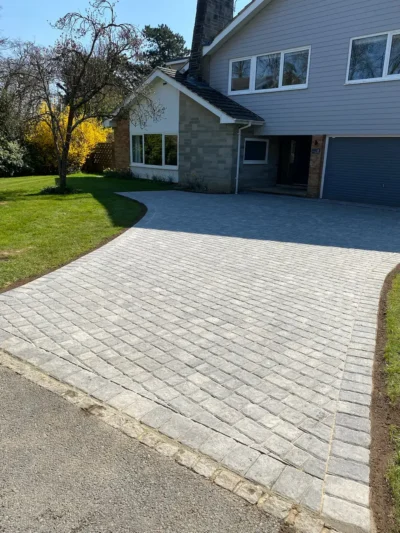 Wide view of grey block-paved driveway with contrasting edging.