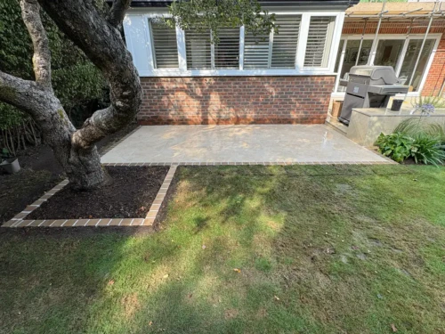 Completed paved patio with contrasting edging around a tree bed.