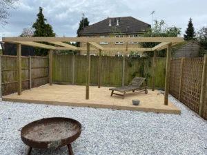 Timber pergola over garden decking, with trellis screening alongside.